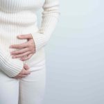 woman holding her lower abdomen frequent uti symptoms in women